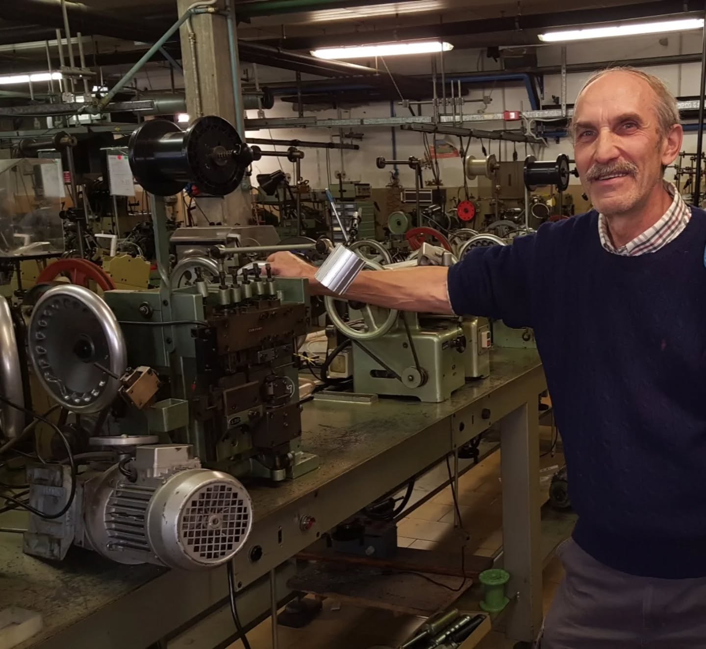 Agostino Bortoli accanto a una macchina per la produzione di catene